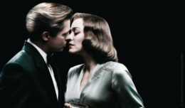 Marion Cottillard und Brad Pitt stehen in Abengarderobe vor einem schwarzen Hintergrund - ihre Gesichter berühren sich liebevoll