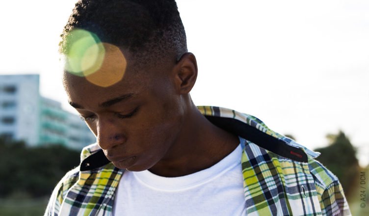 Chiron, gespielt von Ashton Sanders senkt im Gegenlicht betrübt seinen Kopf.