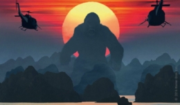 Kong steht vor einem roten Sonnenuntergang während zwei Helikopter ihn angreifen im Film Skull Island