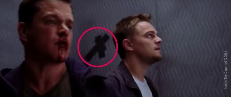Die Hauptcharaktere aus The Departed stehen in einem Aufzug mit Kreuz an der Wand