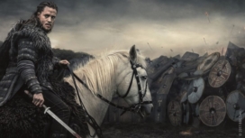 Uhtred sitzt auf einem weiten Pferd vor dem Schildwall einer Armee und dreht sich um