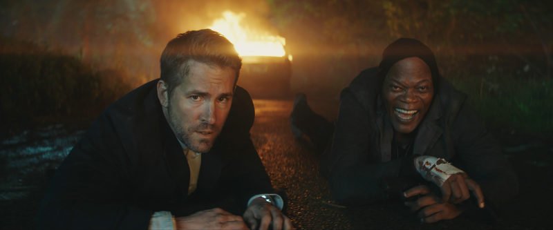 Ryan Reynolds und Samuel L. Jackson auf einer Straße in Szenenbild von Kritik Killer's Bodyguard