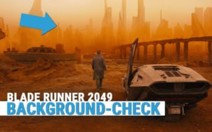 Blade Runner K steht neben einem Auto und starrt auf die rot-gelbe Skyline einer Mega City mit vielen Hochäusern
