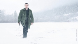 In der Rolle des Kommissar Harry Hole watet Michael Fassbender mit einer Pistole bewaffnet durch tiefen Schnee in Schneemann 2017