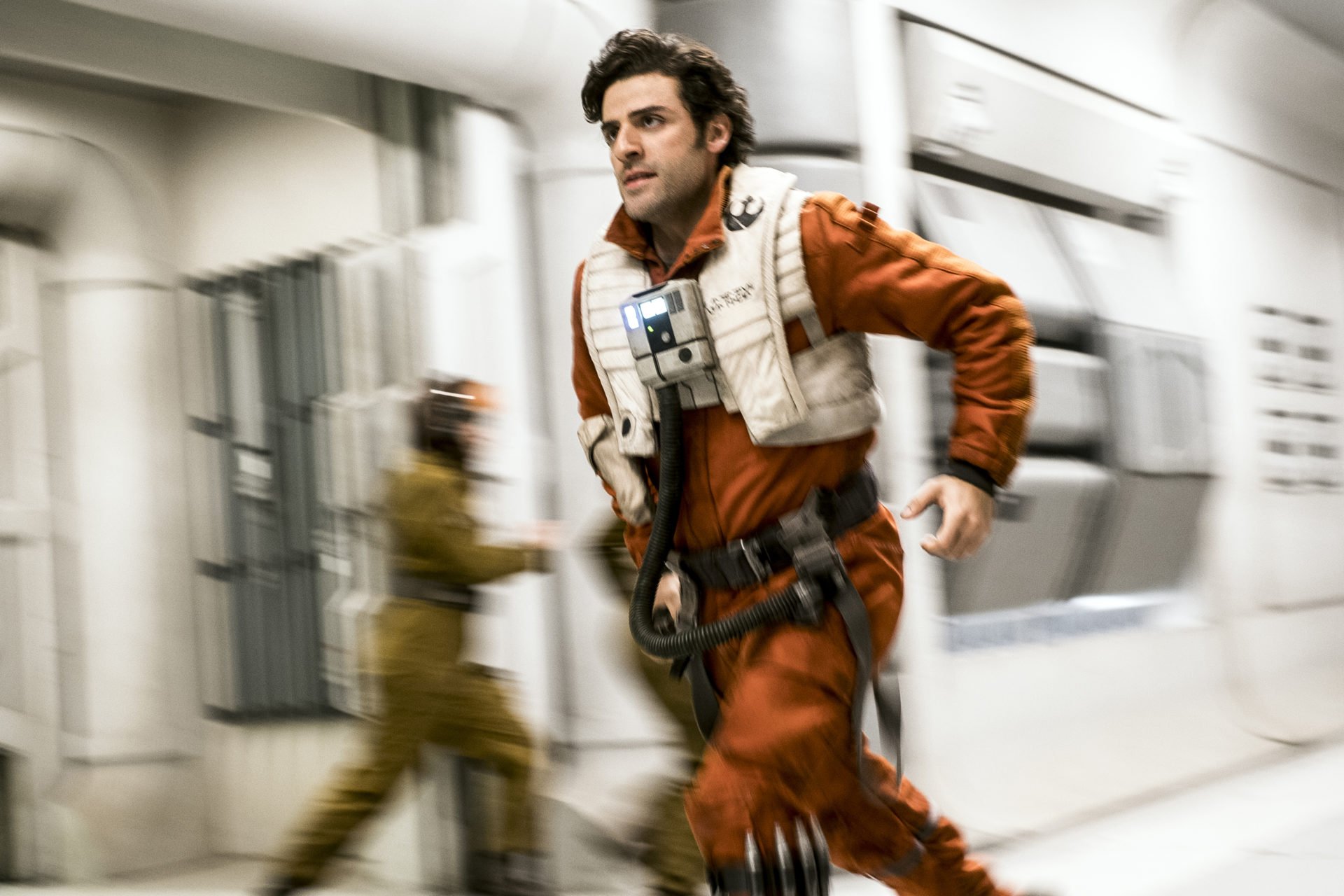 Oscar Isaac als Poe Dameron rennt einen Korridor entlang in Star Wars die letzten Jedi