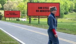 Frances McDormand steht vor drei roten Anzeigetafeln im Titelbild für die Kritik 