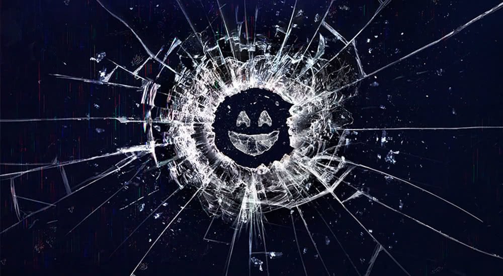Eine zersprungene Glasscheibe die einem Smiley Gesicht ähnelt auf dem Plakat zu Black Mirror