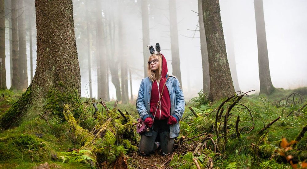 Madison Wolfe als Barbara kniet in einem Wald in I Kill Giants