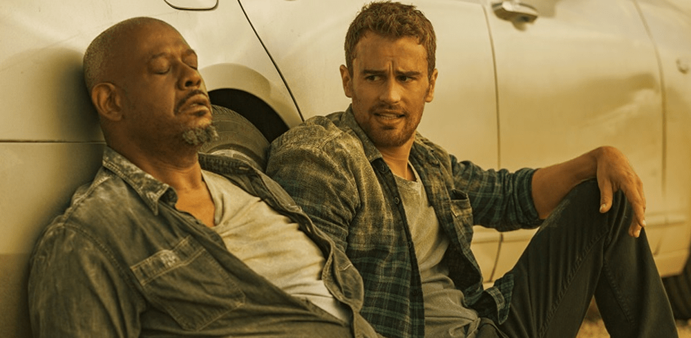 Theo James als Will und Forest Whitaker als Tom unterhalten sich am Boden sitzend vor einem Auto miteinander in How it Ends auf Netflix