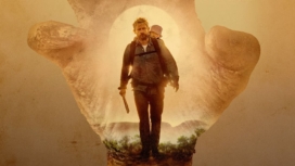 Martin Freeman als Andy mit einem Baby auf dem Rücken und Machete in der Hand im australischen Outback in Cargo auf Netflix.