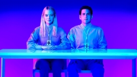 Die Hauptdarsteller von Maniac sitzen in purpurnem Licht an einem Tisch auf dem Plakat zu Maniac Staffel 1