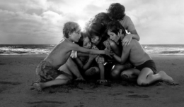 Titelbild für Kritik Roma mit einer Familie, die sich in den Armen liegt auf einem Strand