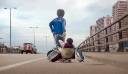 Poster für Kritik Capernaum Stadt der Hoffnung mit Zain der Baby in einem selbstgebauten Wagen über die Straße zieht.