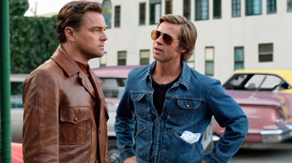 Rick Dalton Leonardo DiCaprio) und Cliff Booth Brad Pitt) vor parkenden Autos.