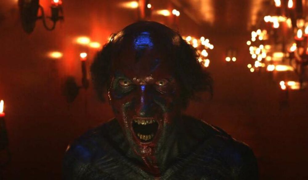 Das gruselige, entstellte, rote Gesicht eines Dämon blickt mit offenem Mund Richtung Kamera